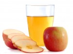 Rodajas de manzanas junto a un vaso de vinagre de sidra de manzana