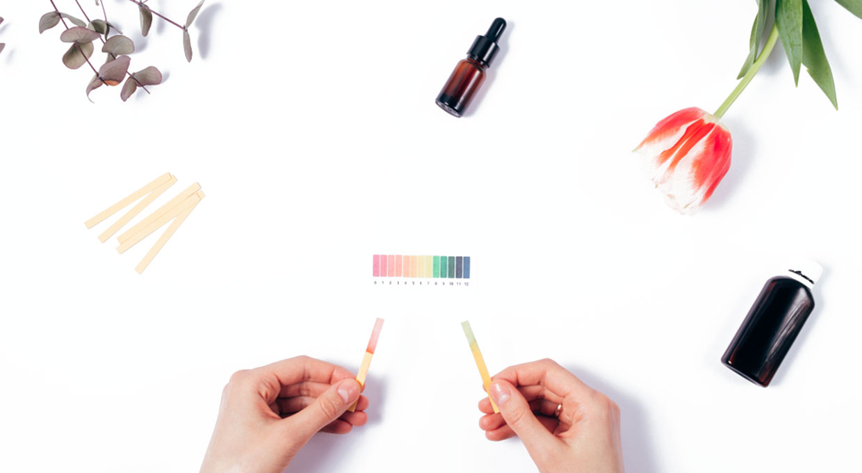 Person evaluating the pH of skin care products using litmus strips